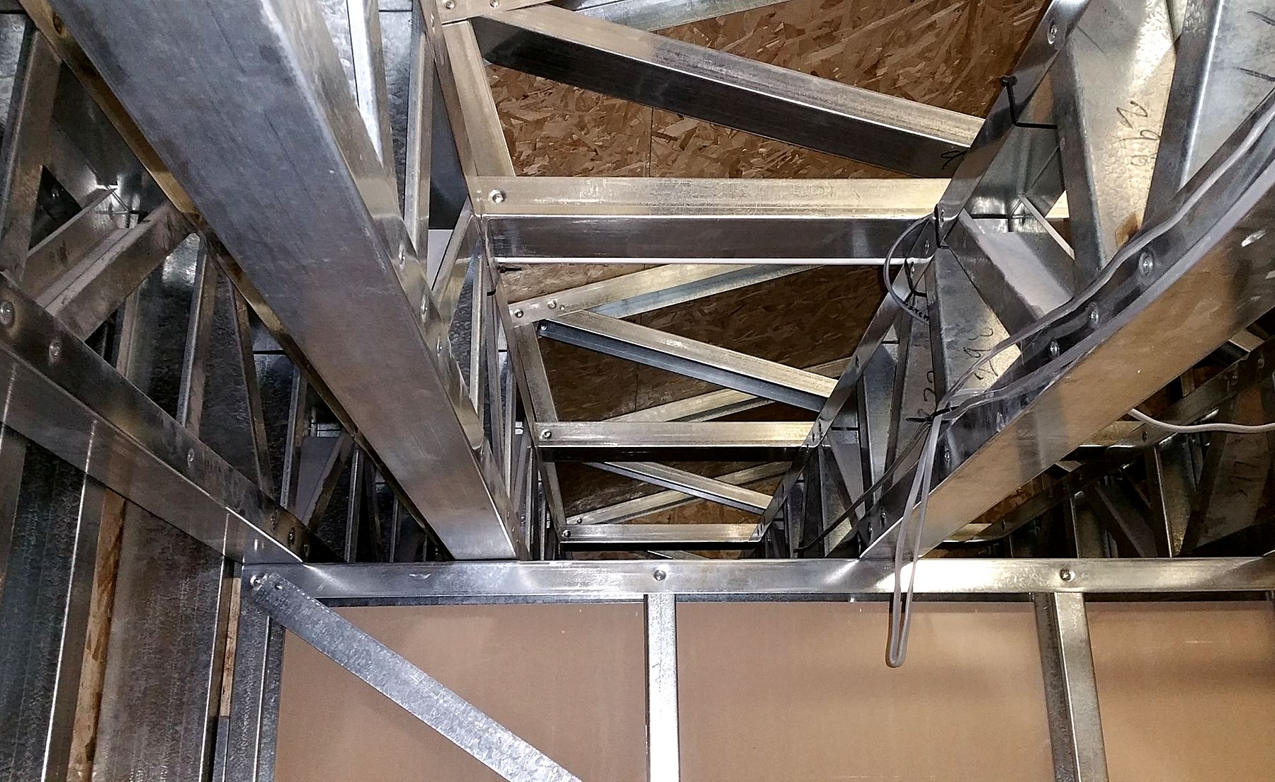 Looking up at screw-fixed connections between light gauge steel trusses and joists